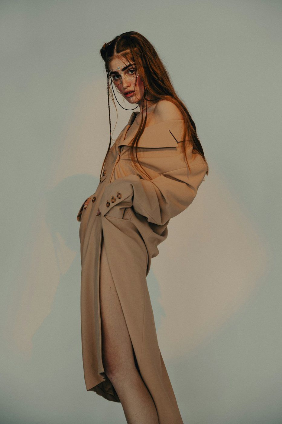 Model in a long beige coat, studio