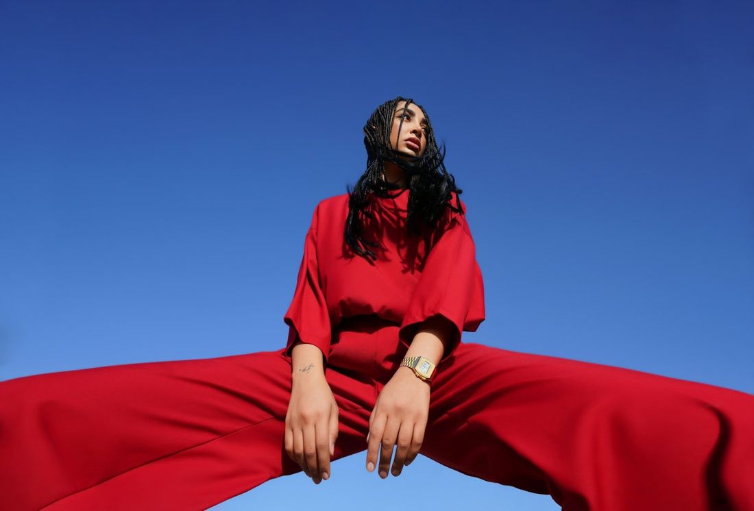Model in a red outfit against the sky